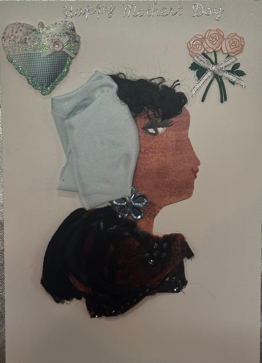 A handmade card titled "Happy Mother's Day" in silver glitter that can also double as an art piece. It shows a profile of a dark-skinned woman with a light blue fabric headwrap and a black velvet ruffled top. In the background are pink embroidered roses and a teal fabric heart.