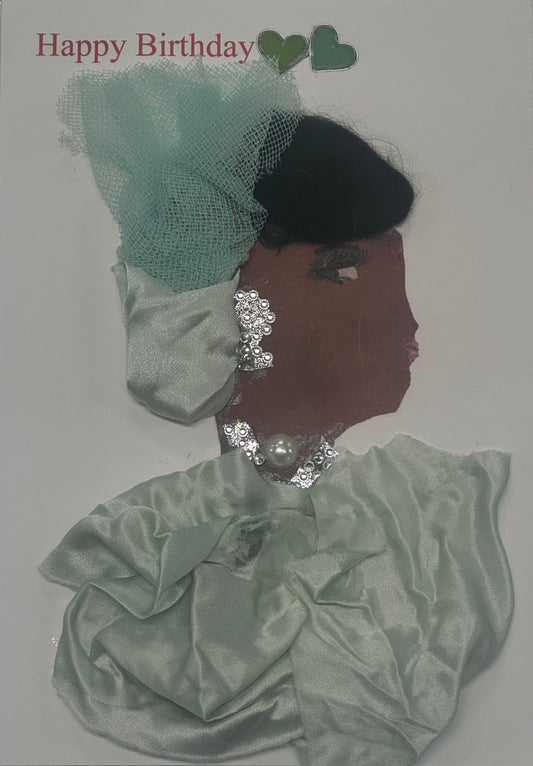 Handmade birthday card that can double as a piece of art, featuring a woman wearing a mint green satin outfit with a decorative tulle fascinator hat. She is adorned with pearls and sparkling silver jewelry, with the neckalce and earrings matching, giving the design a soft pastel elegance. Above the ladys head there are also two green colored hearts that sit in the top middle, next to the written "Happy Birthday" in the top left of card.