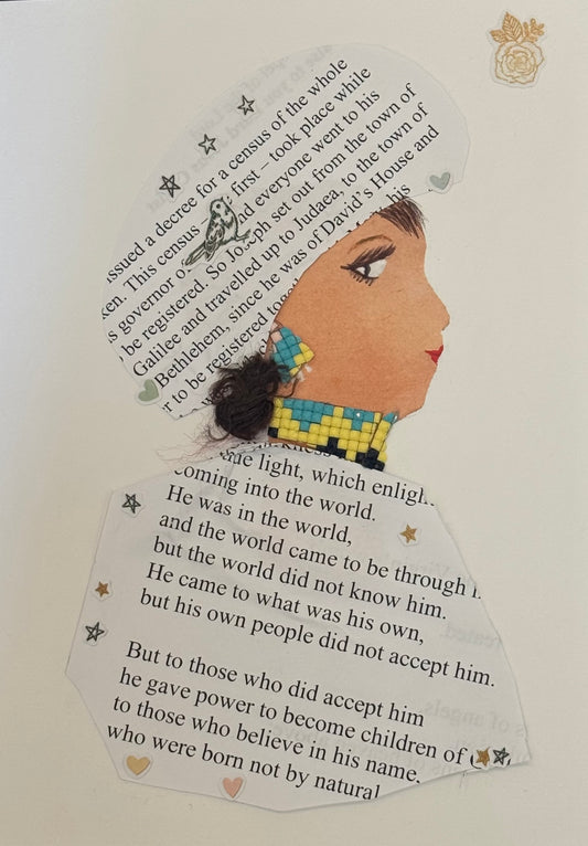 Handmade collage greeting card featuring a right-facing side profile of a woman created primarily from printed text paper. The text, arranged across her headwrap and clothing, appears to be from a book or passage, with visible lines of serif font in black ink on a white background. Her skin tone is a warm light brown, with a defined eye, long lashes, and red lips. She has a small section of dark textured hair visible near the back of her head. She wears colorful square-patterned earrings in blue and yellow.