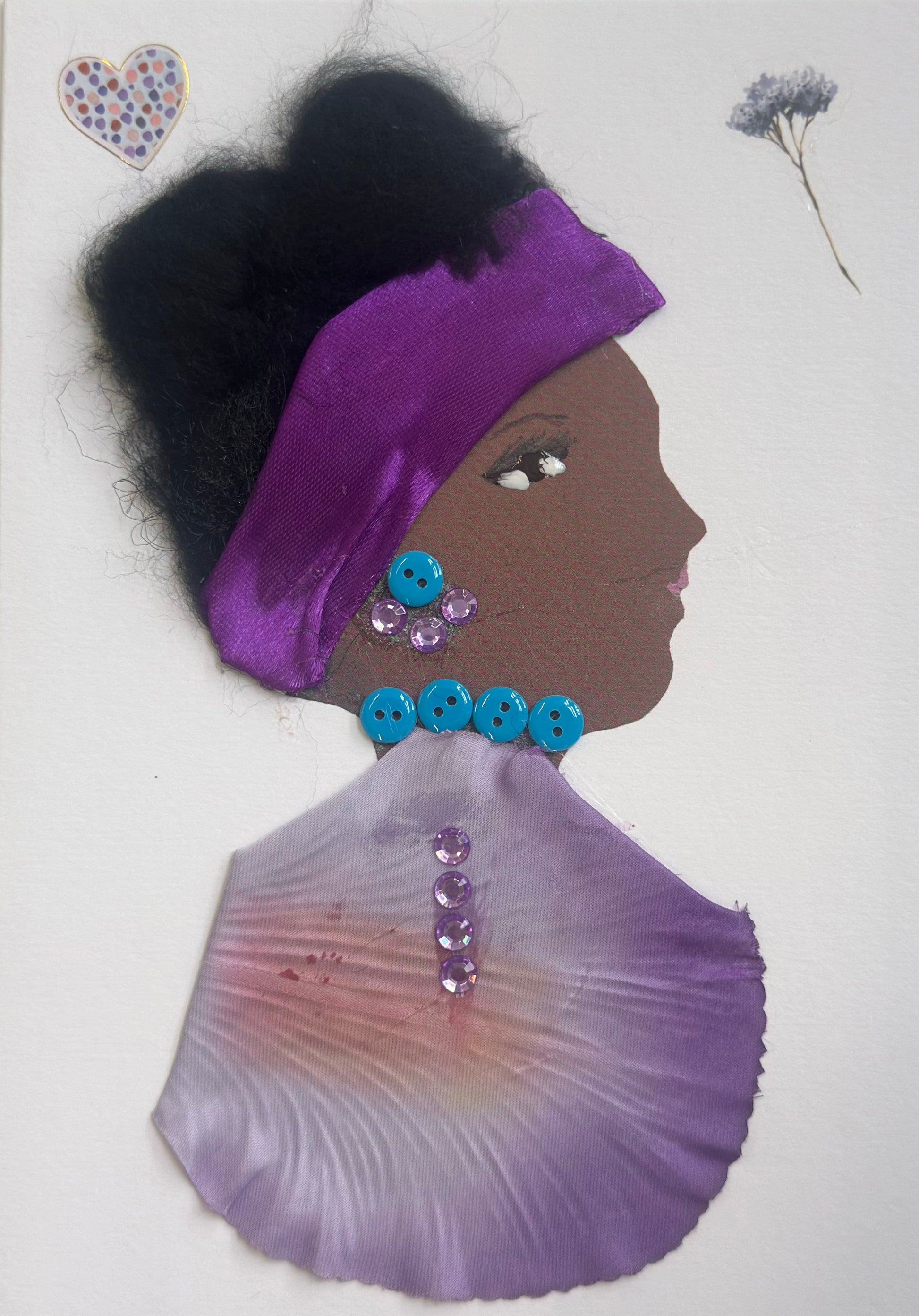 A handmade portrait of “Ayanna Arsenal,” featuring dark textured hair with a purple satin headband, turquoise button necklace, a lilac petal-shaped cloak with gems, and small floral stickers above her.