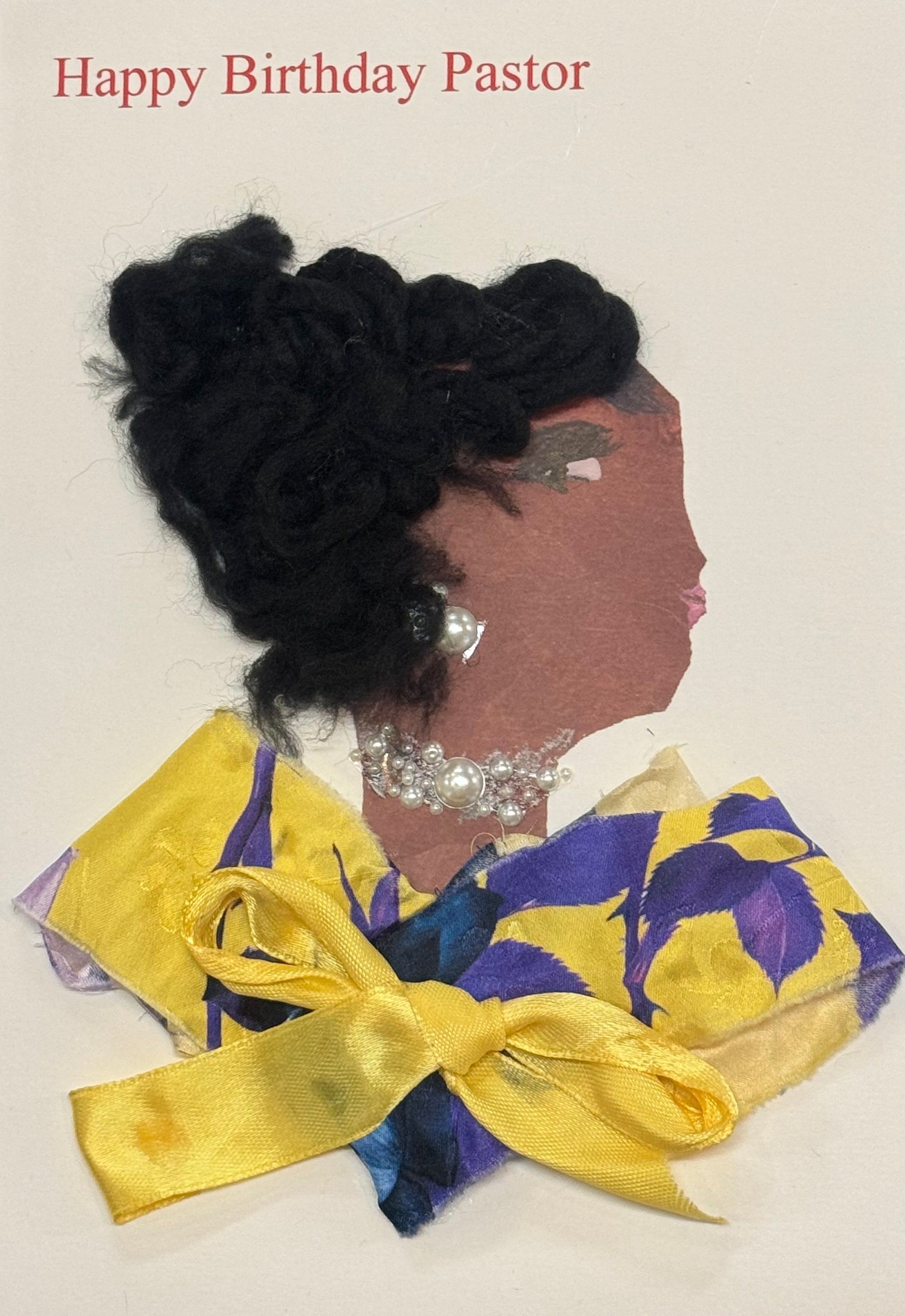 Handmade greeting card that doubles as a piece of art featuring a side-profile collage of a Black woman with textured black hair styled upward, creating height and a sculptural silhouette. She wears pearl earrings and a matching pearl necklace that stand out softly against the darker tones of her hair. Her outfit features a yellow and purple patterned fabric, gathered and tied with a bow that adds structure and visual interest to the clothing. The contrasting colors of the garment create a focal point.