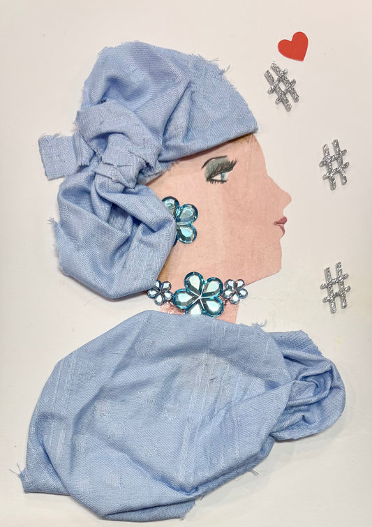A woman wears a matching baby blue headwrap and blouse. Her jewellery is made of blue gems that resemble flowers. A little red heart sits at the top right of the card with three silver hashtags scattered below. 