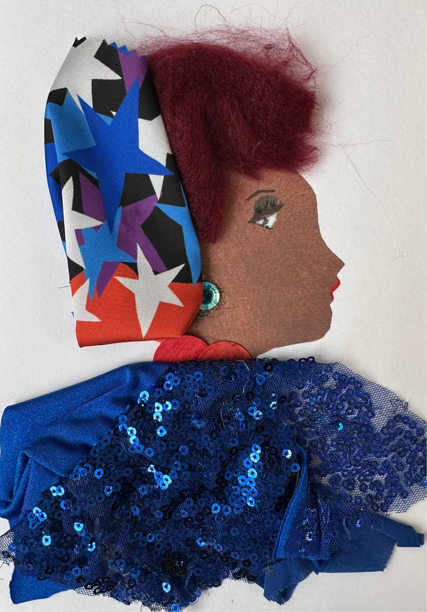 This card depicts a woman named Tottenham Tiffany. She is dressed in a navy blue sequin blouse. Her red hair is tied in a red, white, and blue star-patterned cloth.&nbsp;