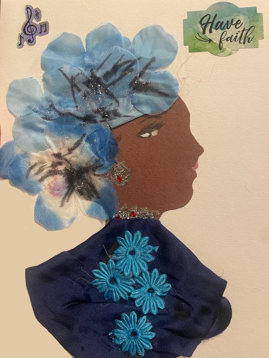 This is a handmade card of a woman named Canada Water Kaitie. She wears a large floral crown in blue, a deep blue shawl with sewn flowers, and sparkling earrings. Stickers say “Have faith” and show musical notes.