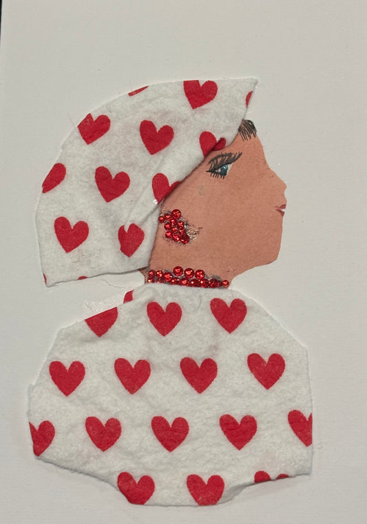 Handmade greeting card that doubles as a piece of art featuring a side-profile collage of a woman set against a clean white background. She wears a white headscarf and matching white outfit, both carefully decorated with evenly spaced small red heart patterns that create a soft, romantic rhythm across the design. Her jewelry includes bright red rhinestone earrings and a matching necklace that catch the light and add dimension to the otherwise minimal palette. 