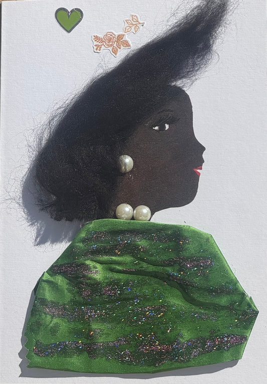 Handmade greeting card that can double as a piece of art featuring a womans profile with textured black hair, pearl earrings and necklace, and a green glittered shawl, with small decorative stickers above on a white background that are depict a green and silver heart, as well as two small detailed gold flowers that are placed toward the left of the card and above her head. 