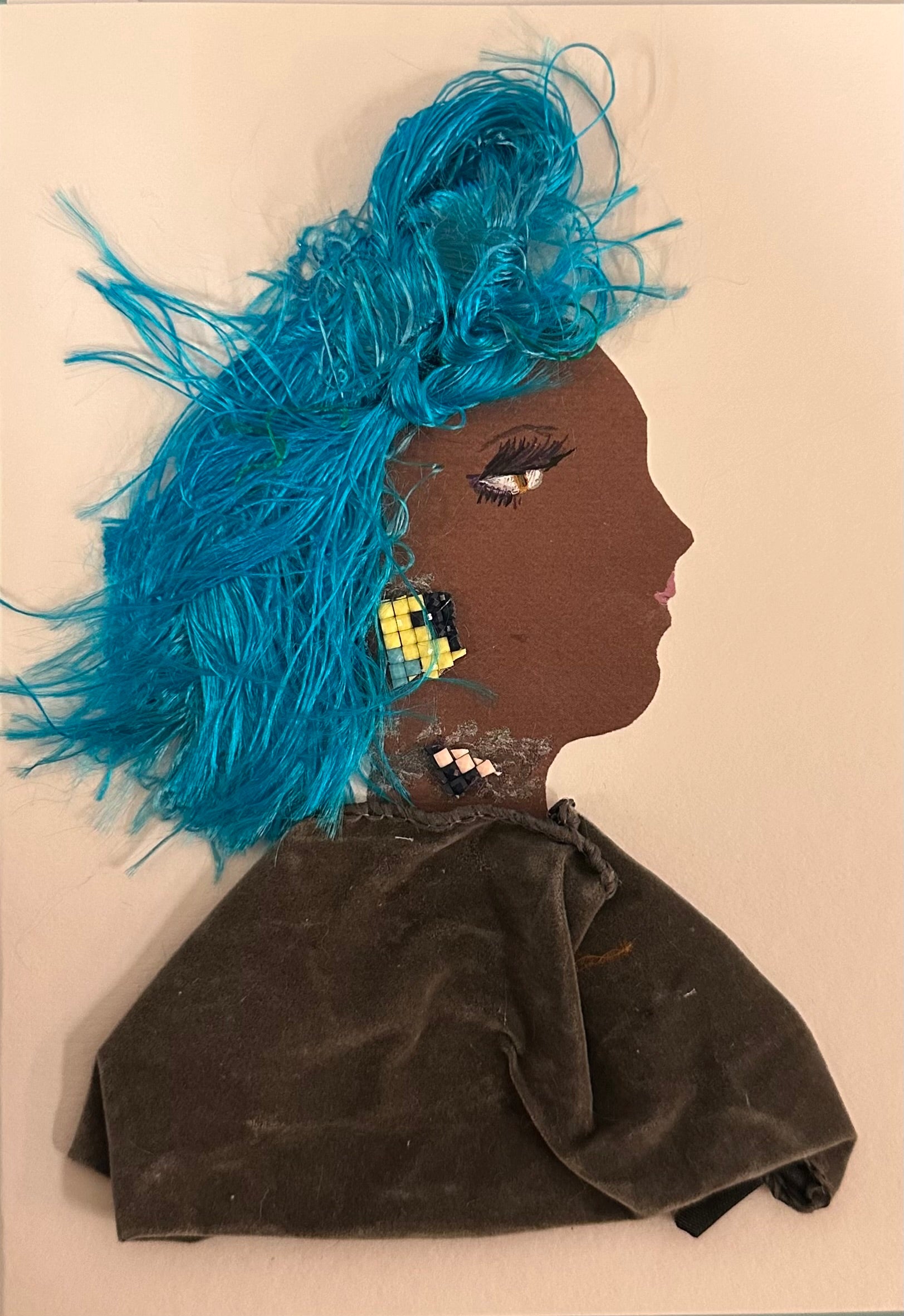 A handmade portrait of a woman with bright blue textured hair, dark brown skin, mosaic earrings, and a soft velvet dress, styled with mixed fabrics and artistic detailing