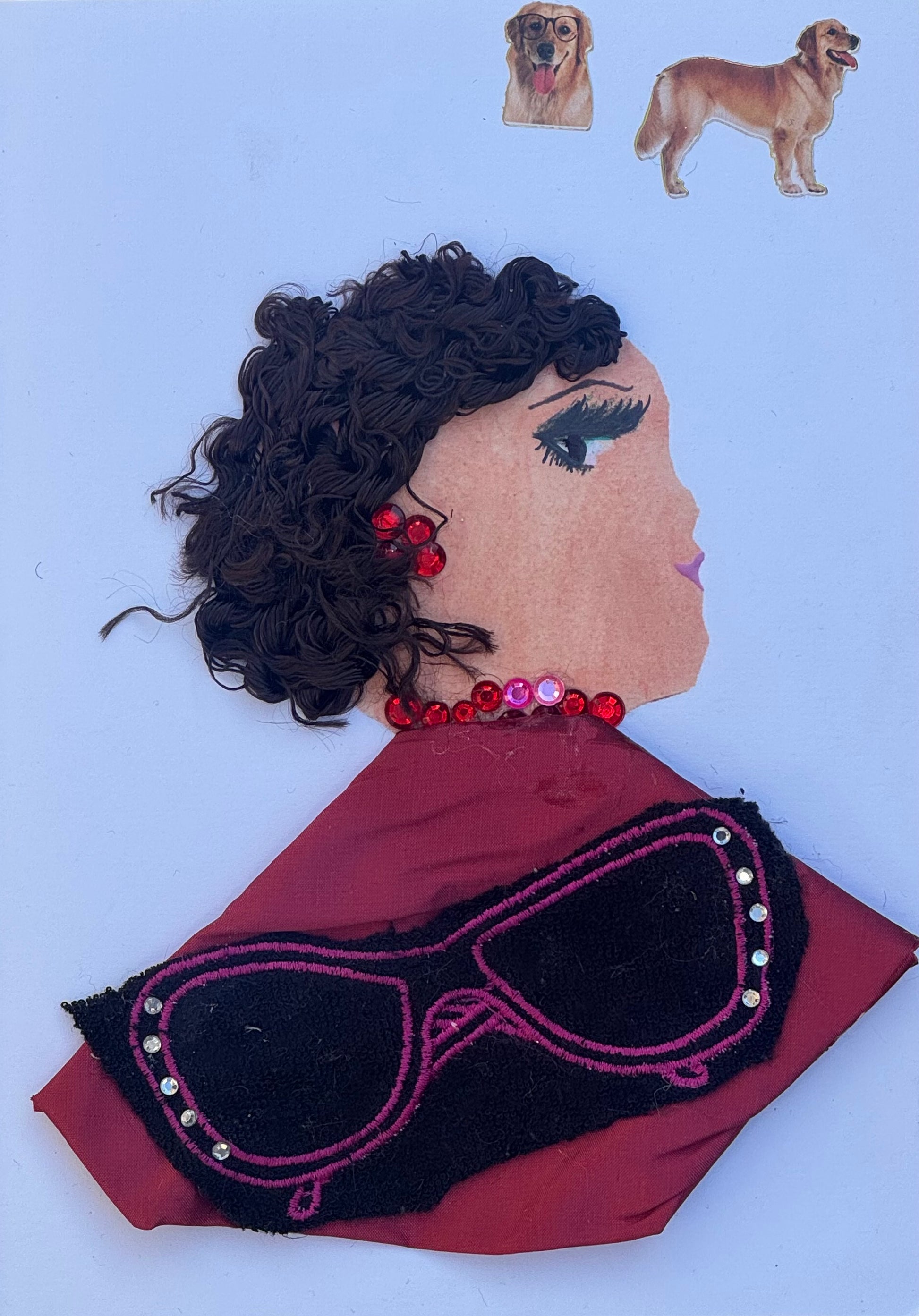 Handmade greeting card that can double as a piece of art featuring a side profile portrait of a woman created with layered collage materials. She has short, voluminous dark brown curly thread hair with loose tendrils framing her face. Her makeup includes bold black lashes, defined brows, and soft pink lips. Red rhinestones form a clustered earring and a coordinating jeweled necklace around her neck. She wears a deep burgundy shawl draped across her shoulders. 