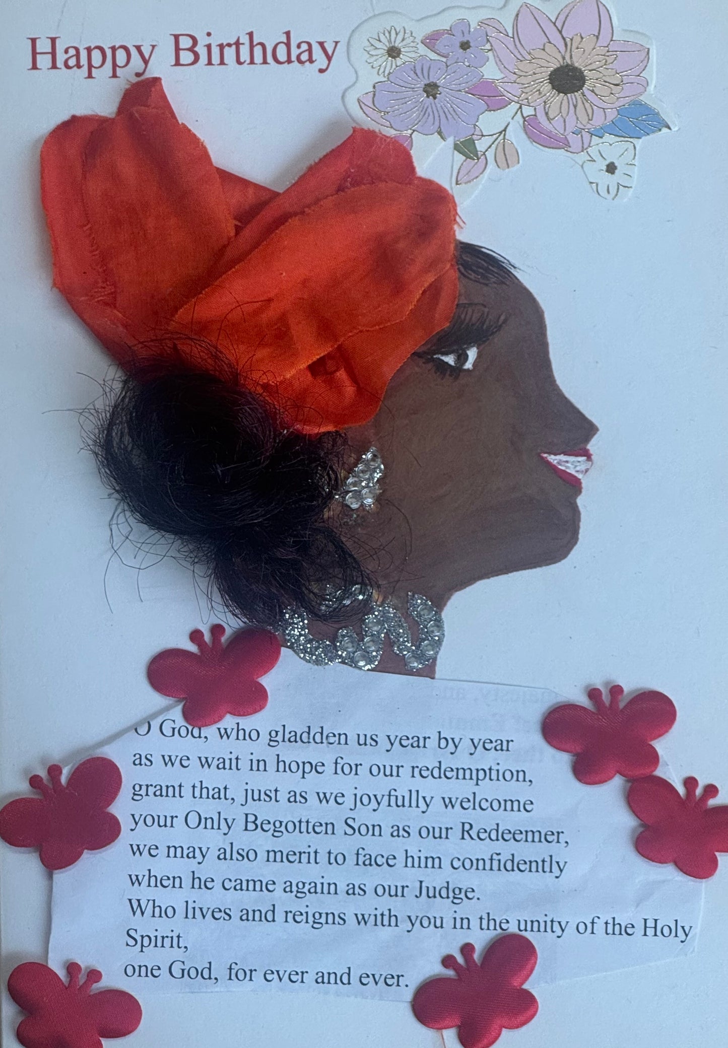 A handmade birthday card showing a smiling woman in profile wearing a large red fabric headwrap tied into a bow. She has sparkling rhinestone earrings and a layered silver rhinestone necklace. Her hair peeks out beneath the wrap. The background includes floral stickers and a printed birthday message at the bottom. Red flower stickers decorate the lower corners.