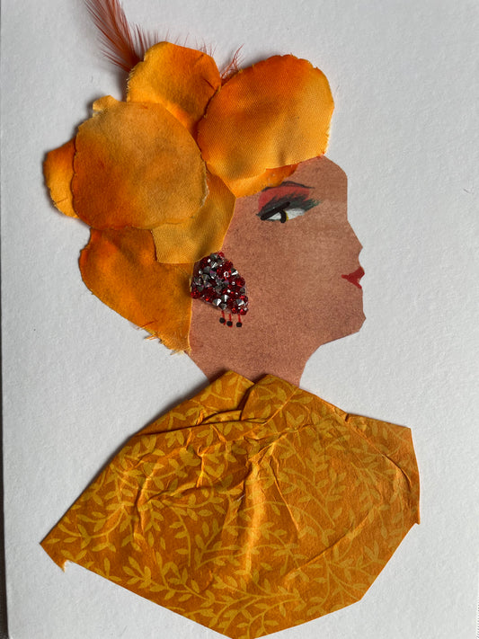 This card depicts a woman who wears an orange headpiece that is made of flower petals with an orange feather that sticks out from the top. She also wears an orange blouse that is covered in a vine pattern. She also wears red and silver earrings that stand out from the rest of her outfit.