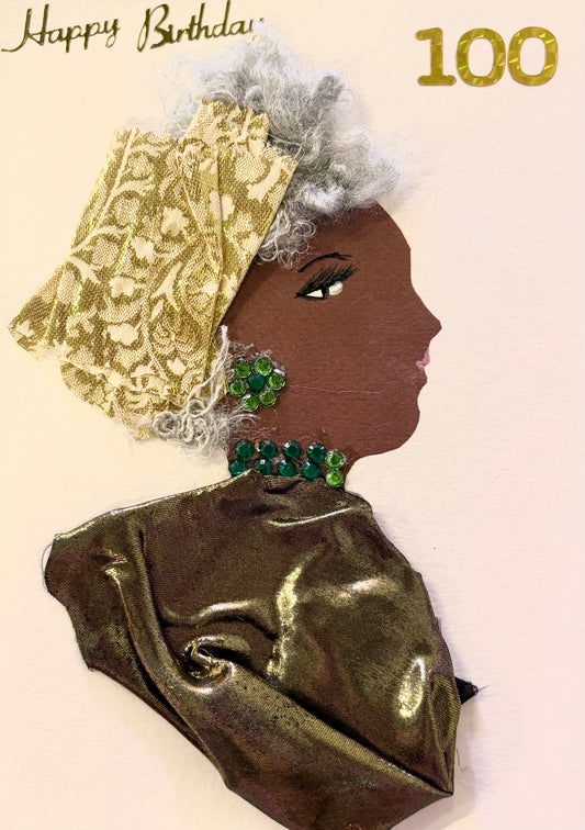 Handmade portrait of a woman in profile, created using mixed media to celebrate a 100th birthday. The woman has grey curly hair, and wears a patterned gold headwrap and shimmering bronze fabric dress. She is adorned with bright green gem earrings and a matching necklace, and the words “Happy Birthday” and the number “100” are written in gold at the top of the image.