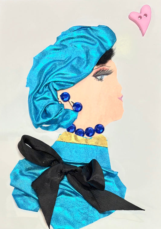 Handmade portrait of a woman in profile. She wears a shiny blue headwrap and matching outfit with a gold collar and a large black bow. Her jewellery includes large blue beads for earrings and a necklace. A small pink heart button is placed above her.