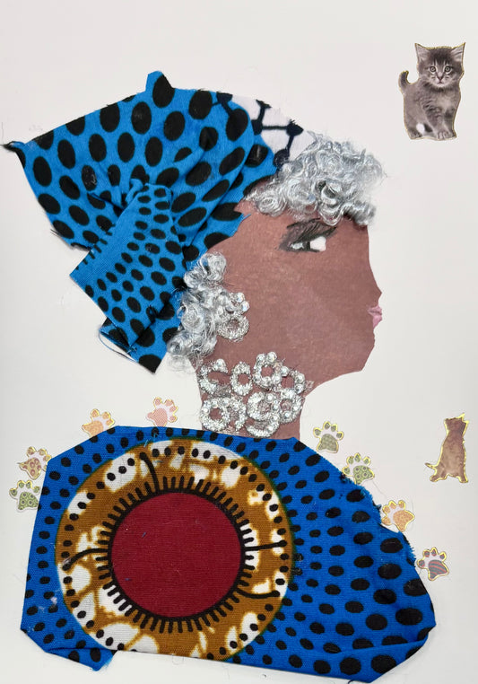 A woman wears a patterned head wrap and blouse with blues, oranges, reds, and polkadots. She wears a silver earring and necklace. Little gold paw prints line her shoulders. Two kittens can be found in the top right corner and middle right of the card. 