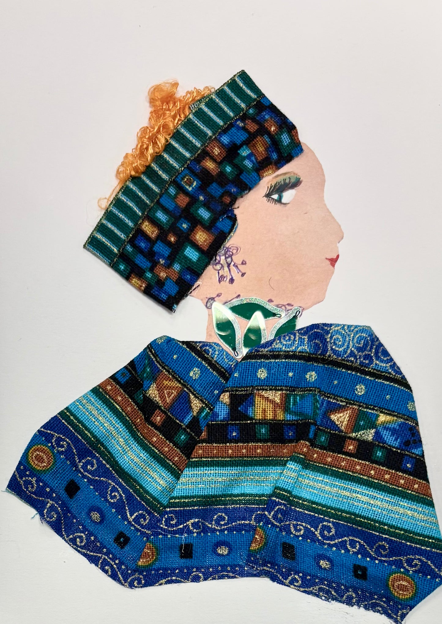 A woman wears a multicoloured headband with her orange hair peaking out the top. Her blouse is matching, featuring different oranges, blues, browns, and teals. She wears a green necklace. 