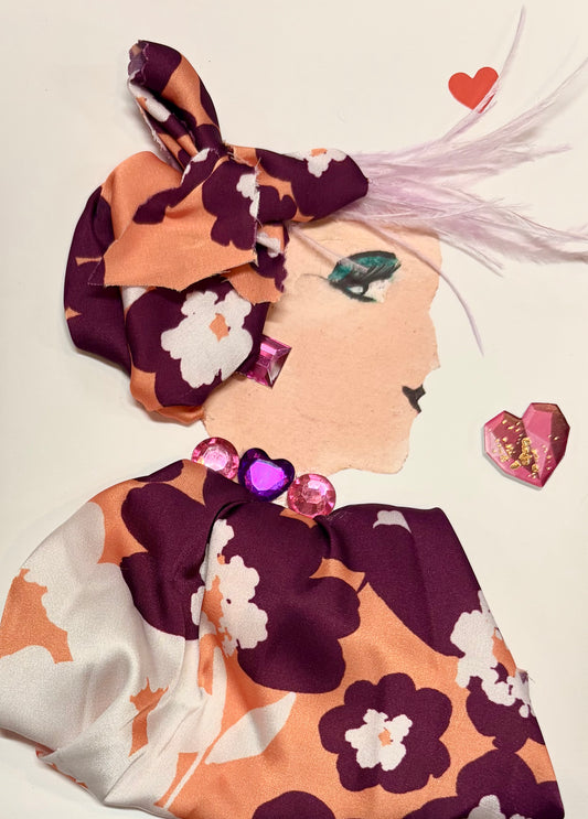 A woman wears a matching headwrap and blouse with light orange, magenta, and white in a subtle floral pattern. Her jewellery is made up of pink gems. There are two hearts, one in the top right corner and in the middle right of the card. 