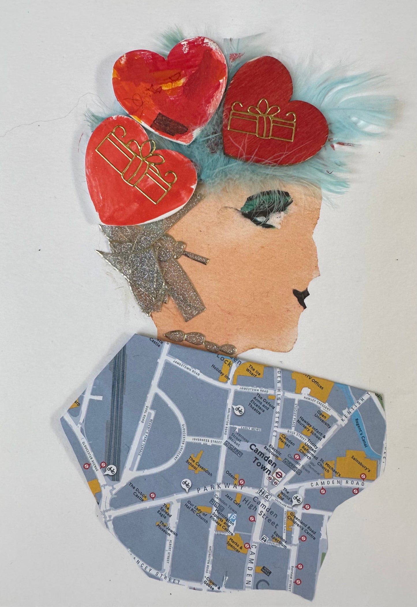 I designed this handmade card of a woman dressed in a blouse made of a map. Her light-blue feather hair is held up with a headband of three large red hearts.