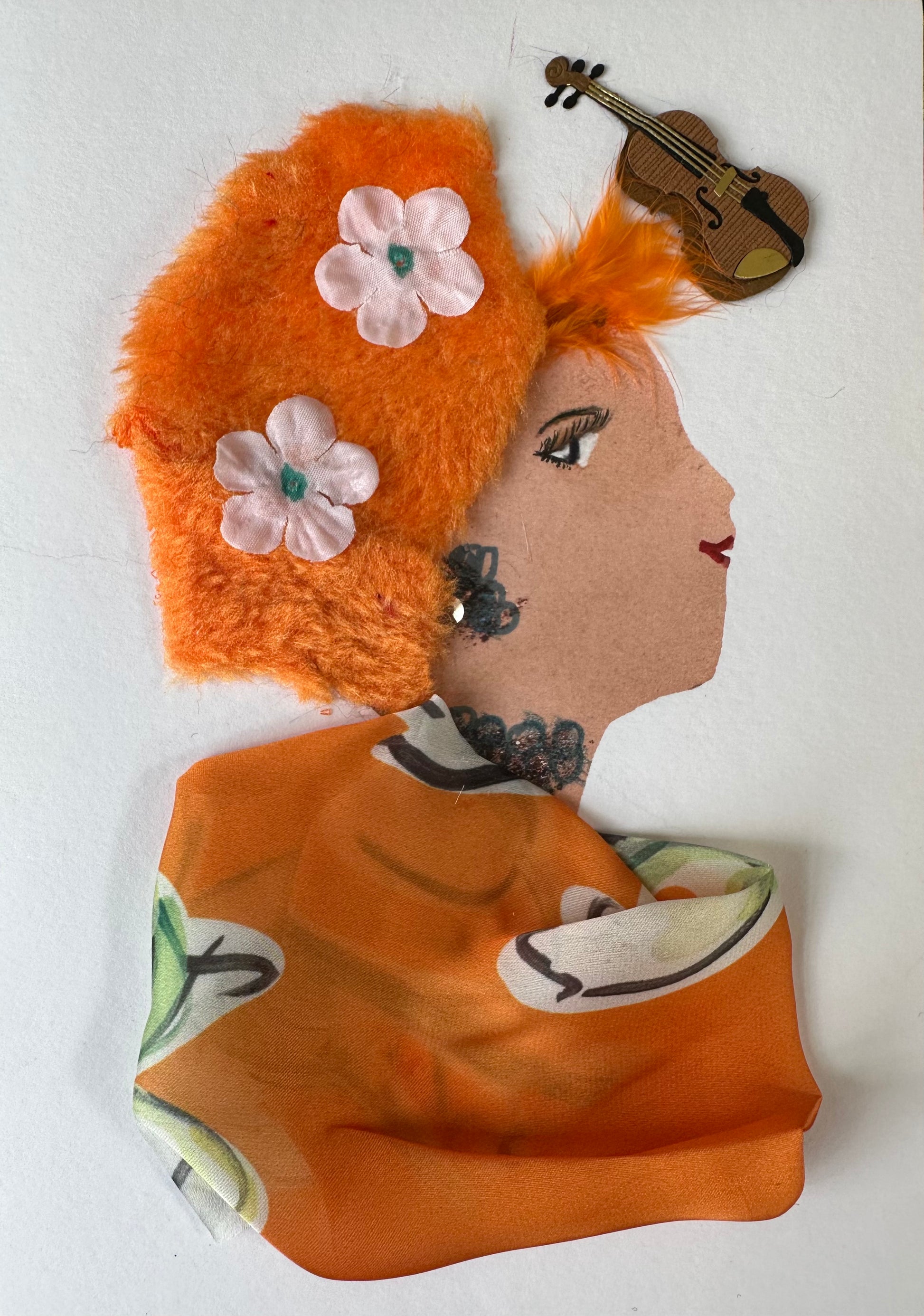 I made this handmade card of a woman draped in a bright orange cloth which matches her orange hair. Her orange hair has two soft pink flowers with green centers. She has an orange feather near the front of her hair and a violin in the upper right hand corner of the card. 