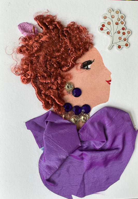 Dulwich Donna is a handmade card I created. She is wearing a royal purple blouse that compliments her red, curly hair. Her necklace and earrings are purple and diamond-like gemstones.