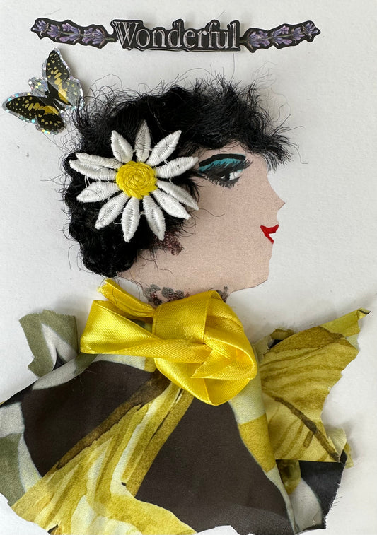 Wonderful Waverly is an handmade card of a woman wearing a yellow and brown blouse. Her black hair is tied together with a large daisy and a butterfly soars next to her. The top of the card read "Wonderful". 