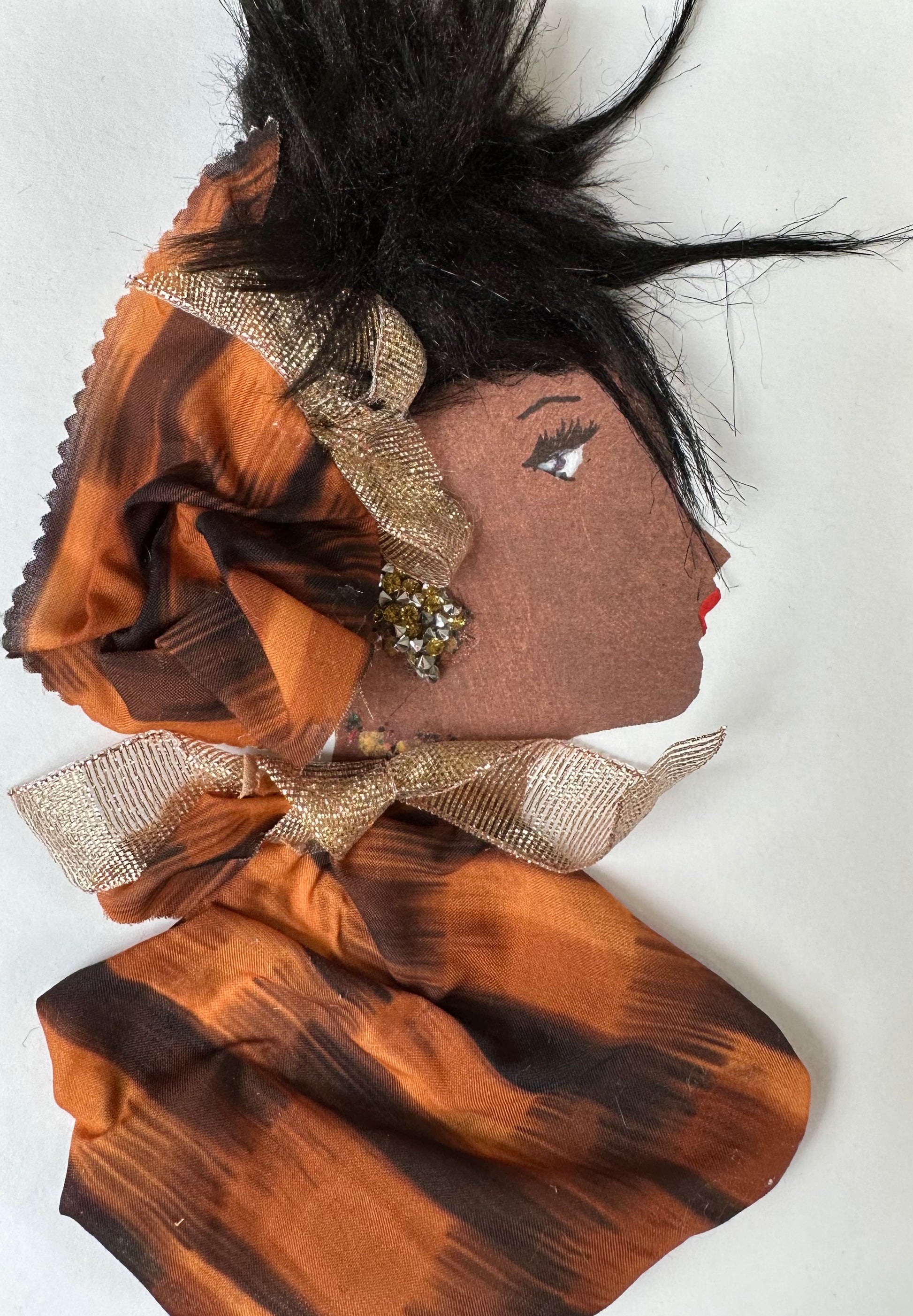 I designed this handmade card of a woman wearing a burnt orange and brown blouse and hatinator. Both pieces are tied together with a gold ribbon, and her earrings at an extra touch a sparkle with the gold.