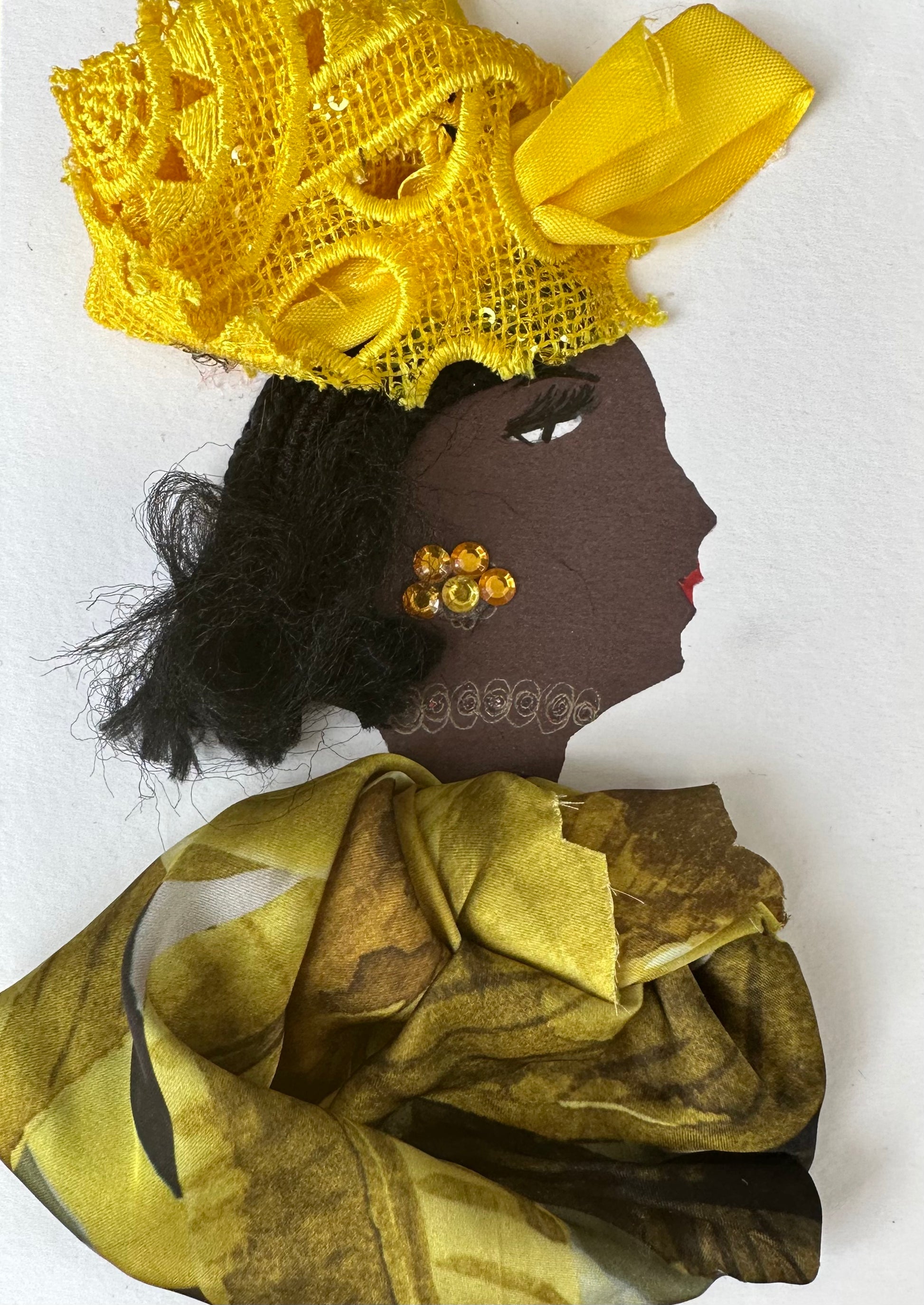 I designed this handmade card of a woman dressed in a yellow and brown patterned blouse. Her hatinator is composed of a lace-like material, and her earrings are golden yellow gemstones. 