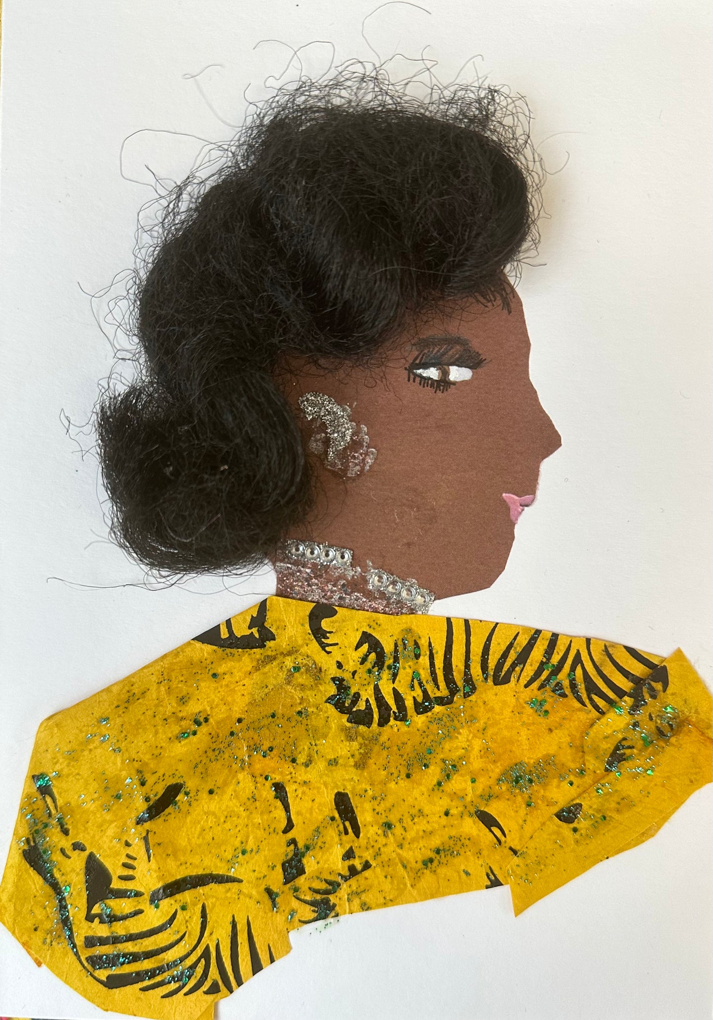 This handmade card is of a woman named Brent Betsy who is wearing a yellow blouse that is patterned with the outline of a zebra. Her earrings and necklace are made up of silver gemstones.