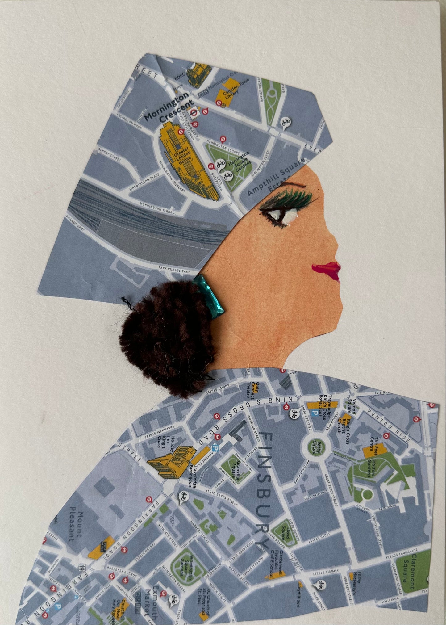 I created this handmade card of a woman wearing a blouse and matching hair piece that are of the map of Finsbury. She has teal earrings that are covered by her black curly hair.
