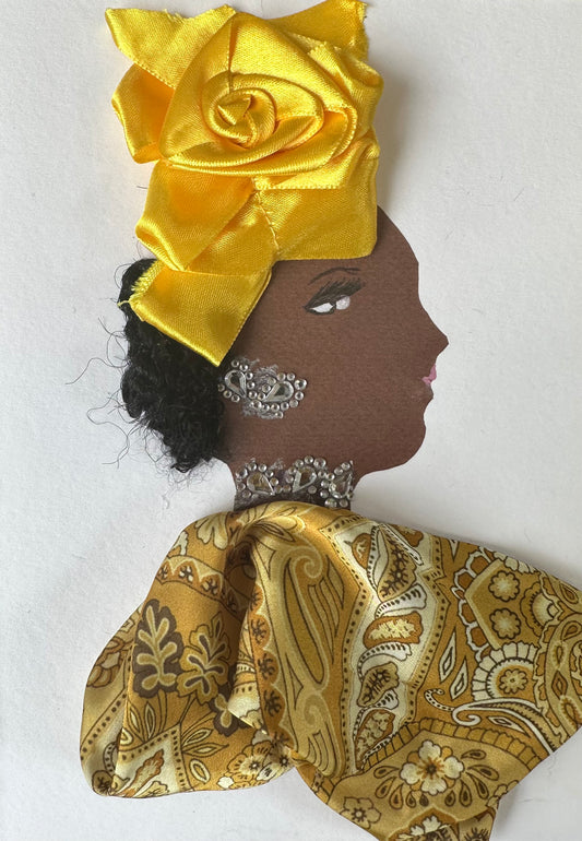 I designed this handmade card of a woman dressed in a medallion and butterscotch patterned top. Her hatinator is made of a yellow like silk material that is folded into a flower shape. She has silver jewellery. 