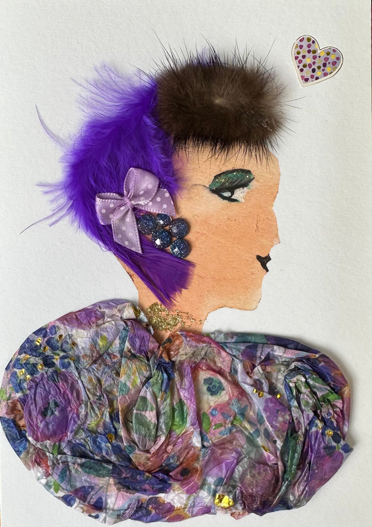 I made this handmade card of a woman wearing a multi-coloured blouse with mainly different shades of purple, but also incorporating green and red. In her hair, she has a bright purple feather pinned with a light purple bow. There is a spotted heart in the right corner.