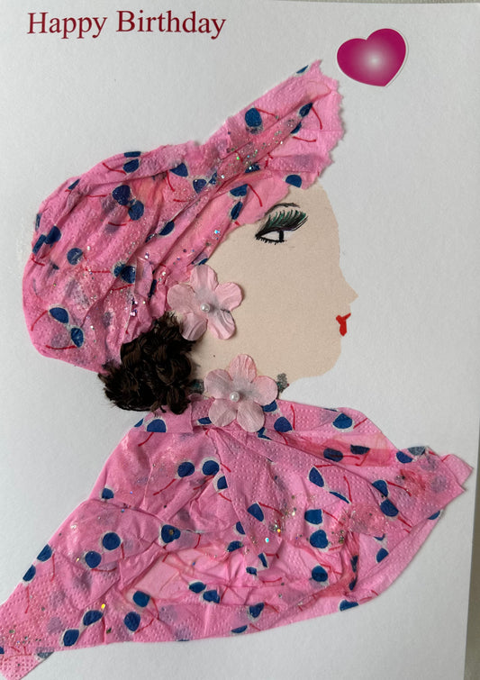 I created this handmade card of a woman wearing a pink blouse and matching hair piece; the blouse is patterned with blue and white sunglasses. She has light pink flowers with a white pearl-like center. The card also contains a pink heart and a "Happy Birthday" message. 