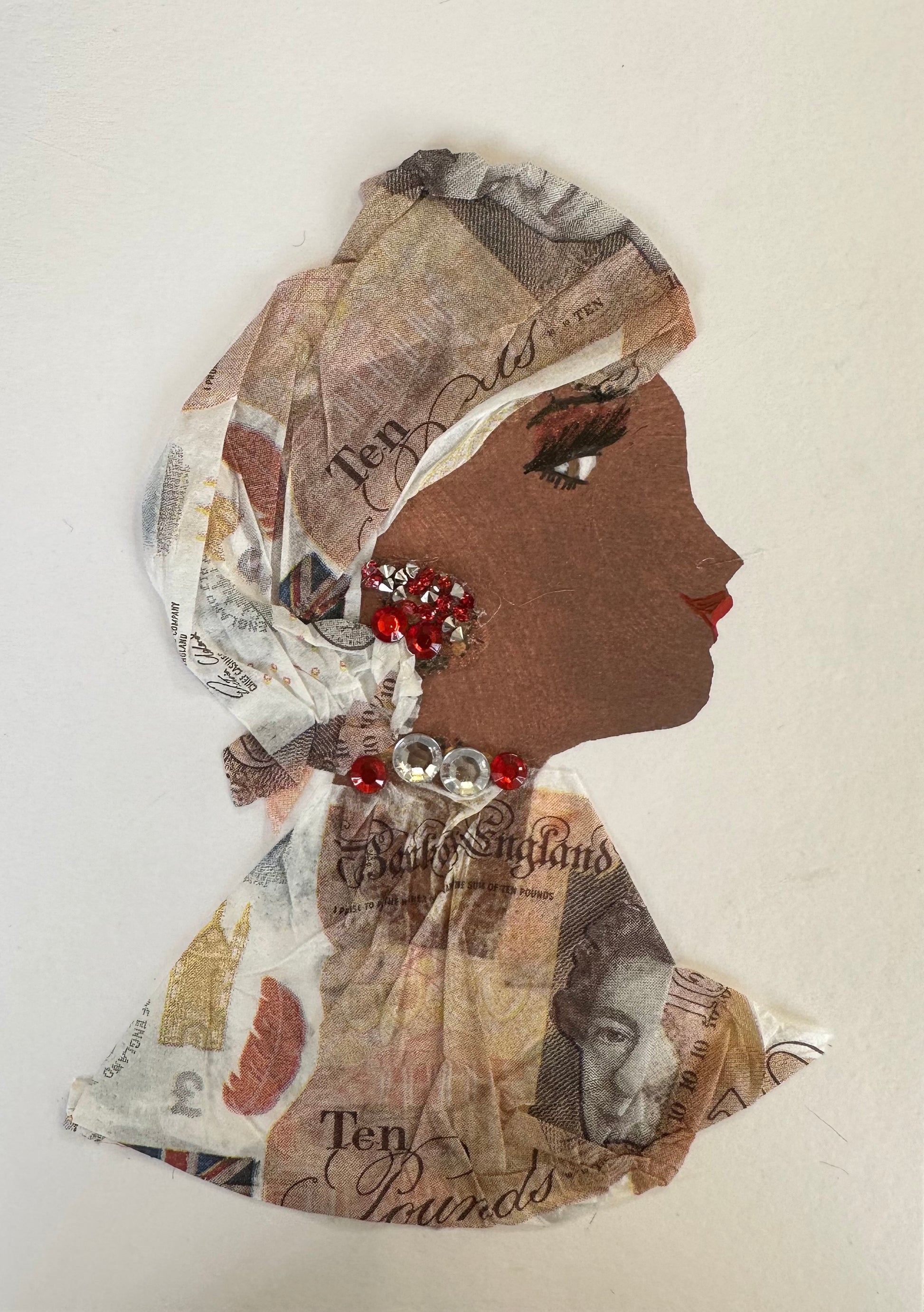 I designed this handmade card of a woman dressed in a paper material hatinator and blouse that have ten pound pattern printed on it. The outfit is completed with silver and red gemstones for her jewellery.