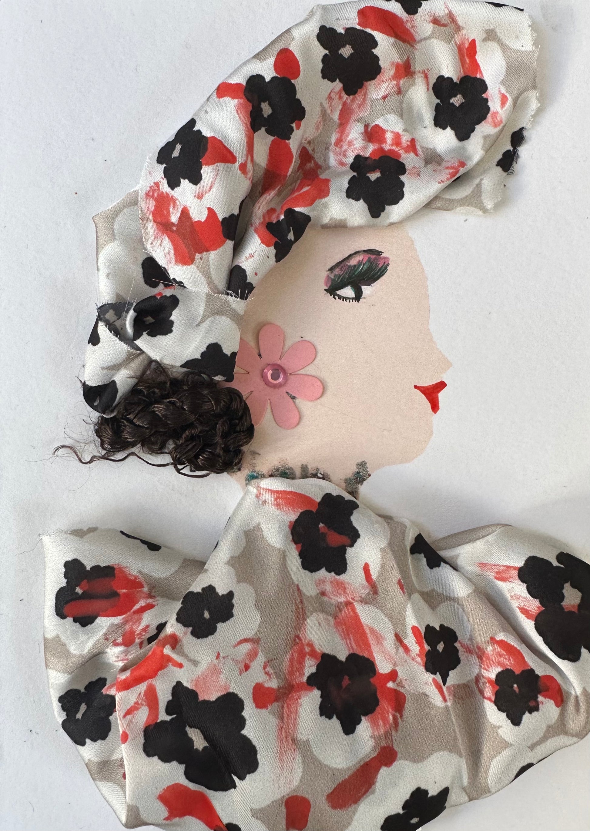 I designed this handmade card of Camden Clarissa who is wearing a red, white, and black floral patterned blouse and hatinator. Her earrings are a light pink flower with a pink gemstone in the center.
