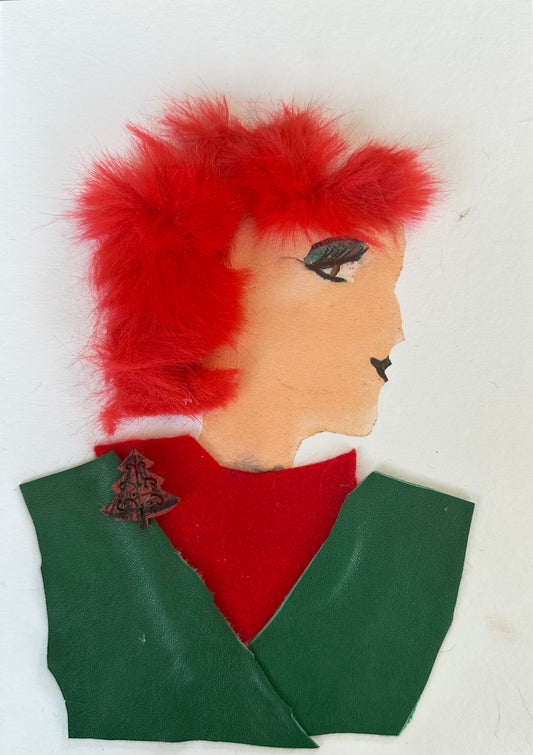  I designed this handmade card of a woman wearing an emerald green blouse with a ruby red undershirt. There is a small Christmas tree pin attached ot the blouse. Her hair is bright red, and she is had green eye shadow.