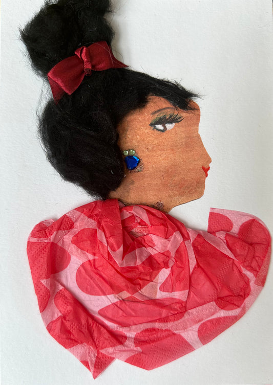 I created this handmade card of Finsbury Fiona. She is dressed in a pink blouse with red hearts. Her dark hair is tied up with a red bow, and she is wearing blue gemstone earrings. 
