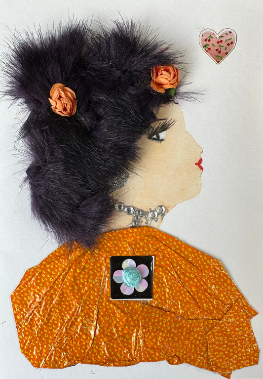 I designed this handmade card of a woman dressed in an orange blouse with small yellow spots. In the center of her shirt is a black square with a flower in its center. Her black hair is completed with orange flowers in addition to her diamond-like necklace.