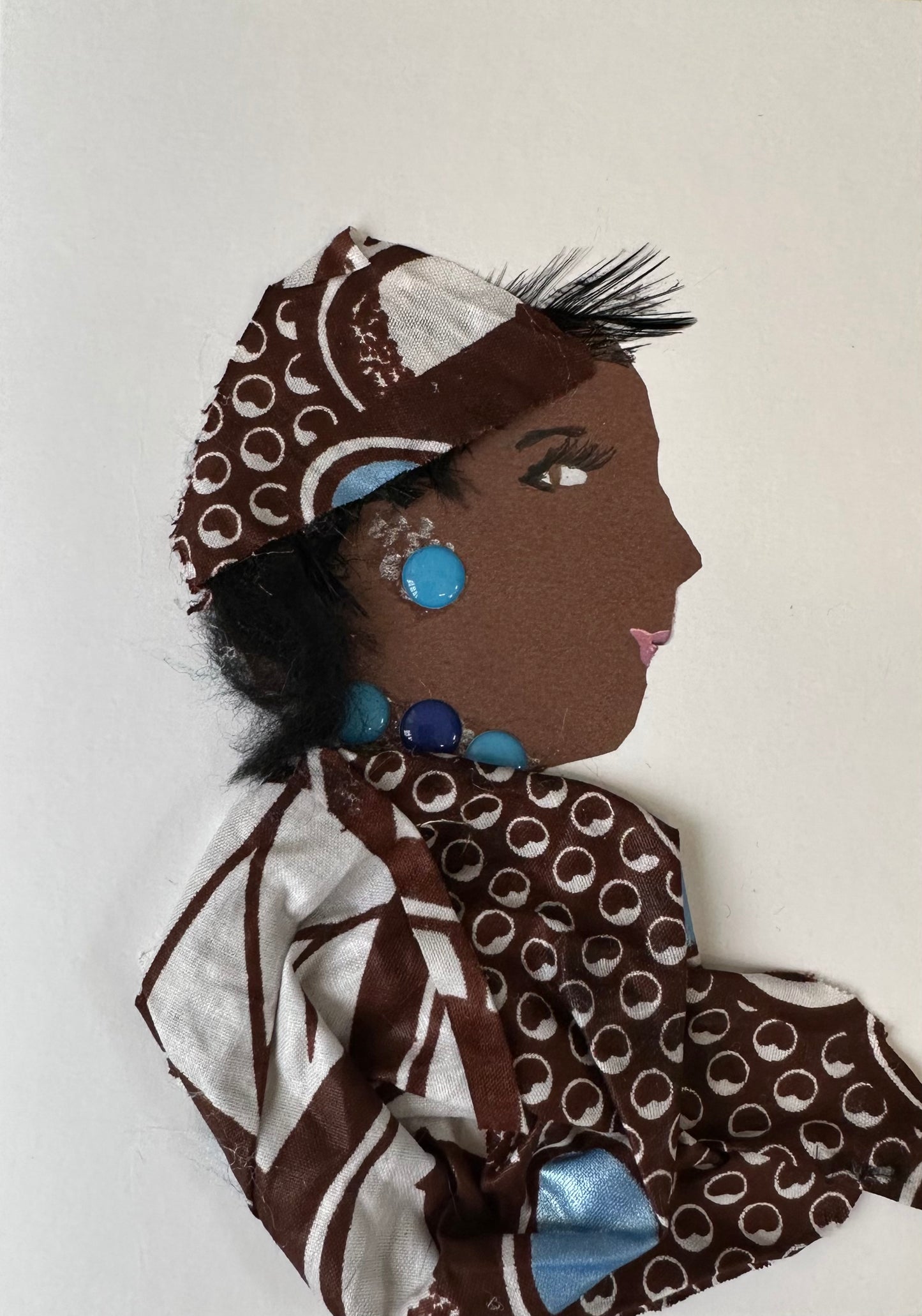 I made this handmade card of a woman draped in a brown and white Ankara material. The outfit is perfectly complete with teal gemstone jewellery.