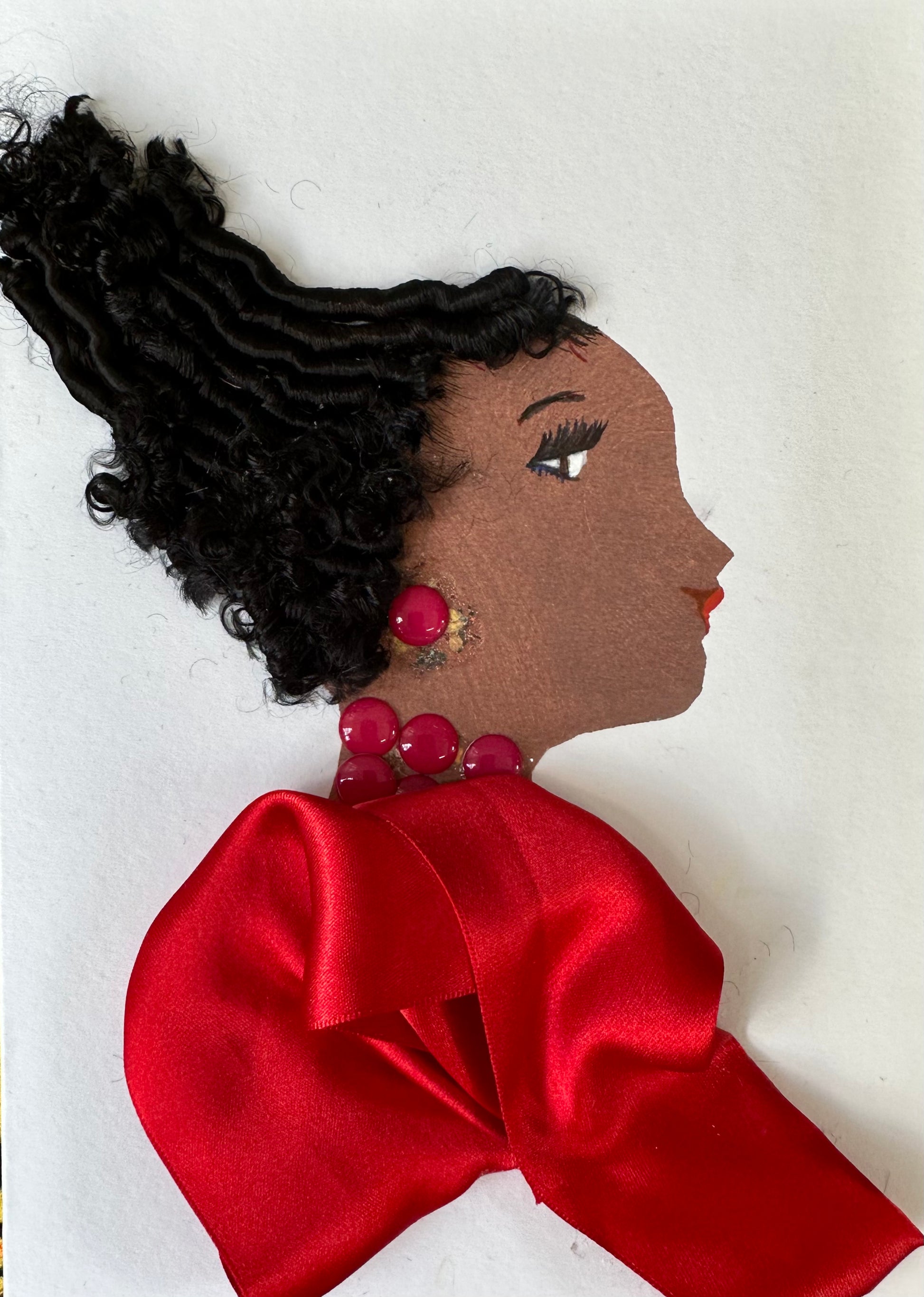 I designed this handmade card of a woman wearing a ruby red, silk-like blouse. She has complimentary red gemstone earrings and necklace.