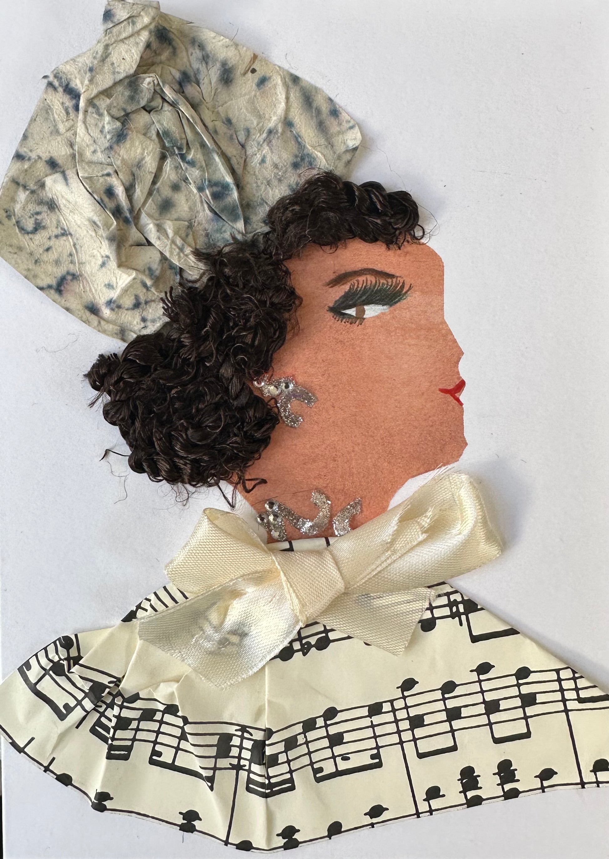 I designed this handmade card of a woman dressed in a white blouse with music notes. Her collar is wrapped with a white bow, and her hatinator is white and gray. Khloe's jewllery is made up of silver gemstones.