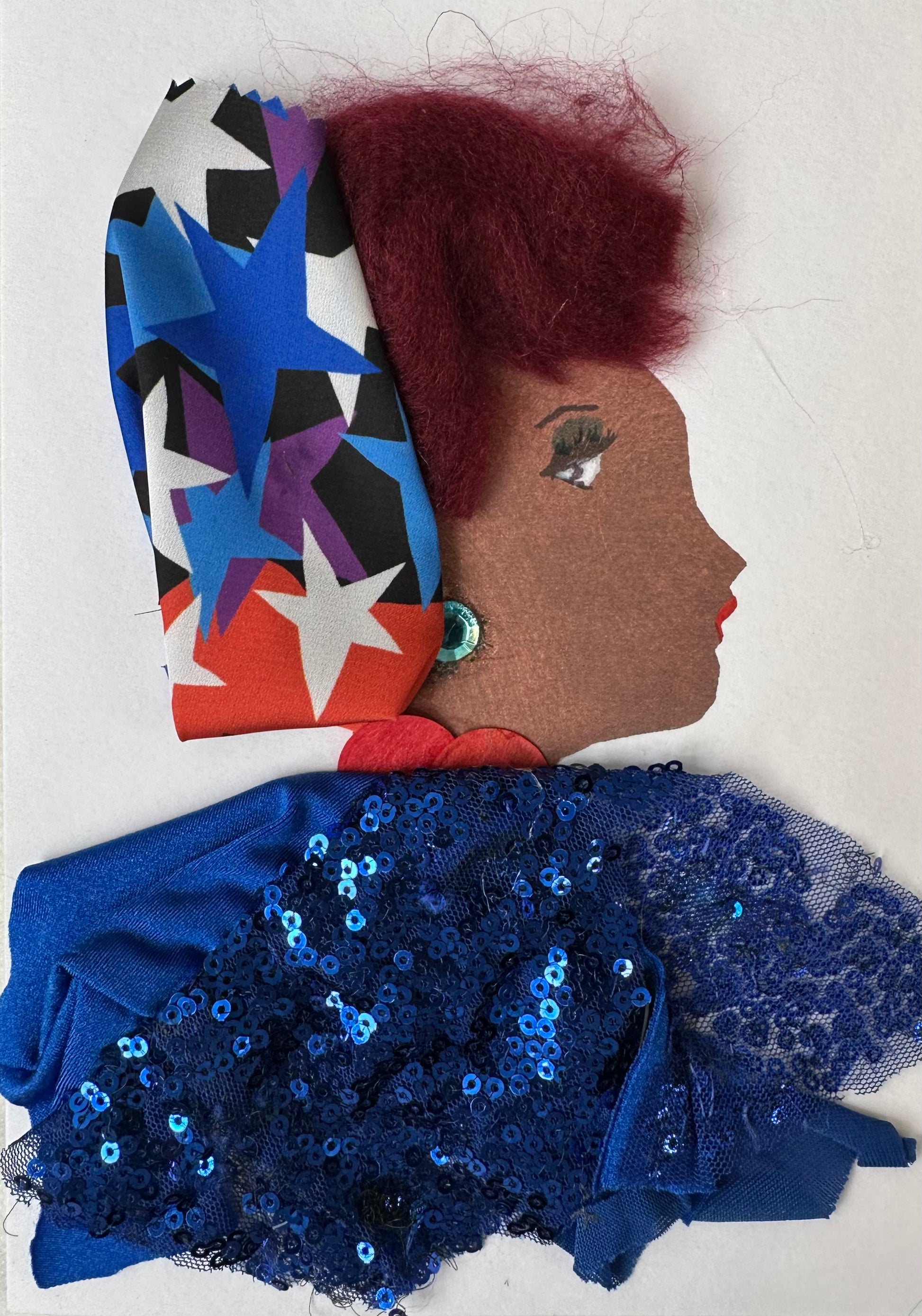 This is a handmade card of Tottenham Tiffany. She is dressed in a navy blue sequin blouse with her red hair being tied in a red, white, and blue star-patterned cloth. 