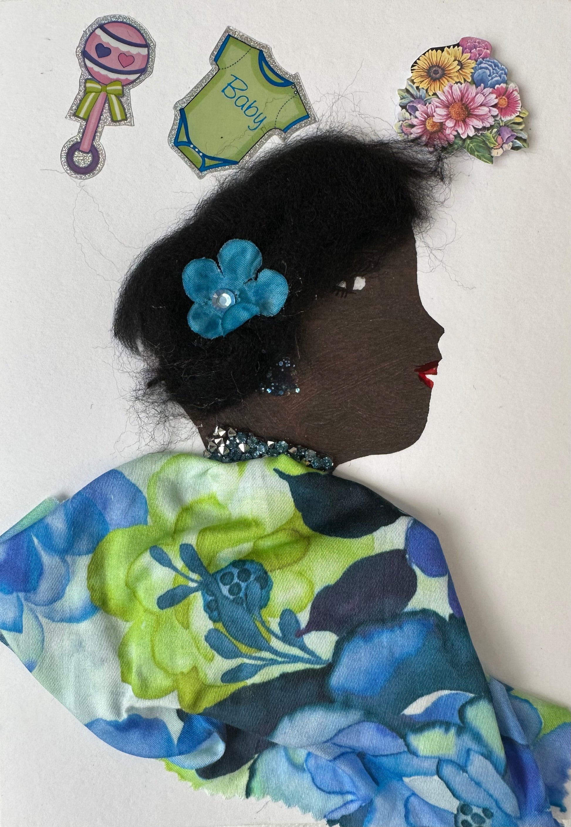 I made this handmade card of a woman wearing a blue and light green floral blouse with a matching blue flower in her hair. The surrounding space contains baby stickers and flowers.