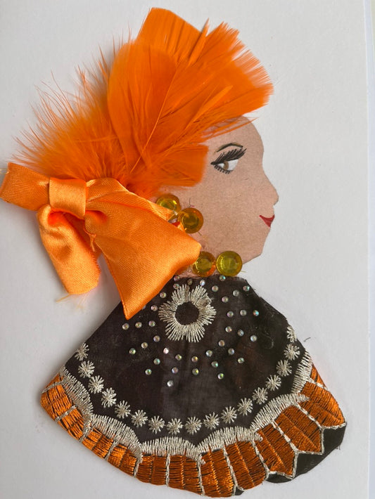 This card is called Antonella. She wears a black and orange patterned blouse and orange feathers in her hair. There is a great orange bow at the bottom of the feathers.