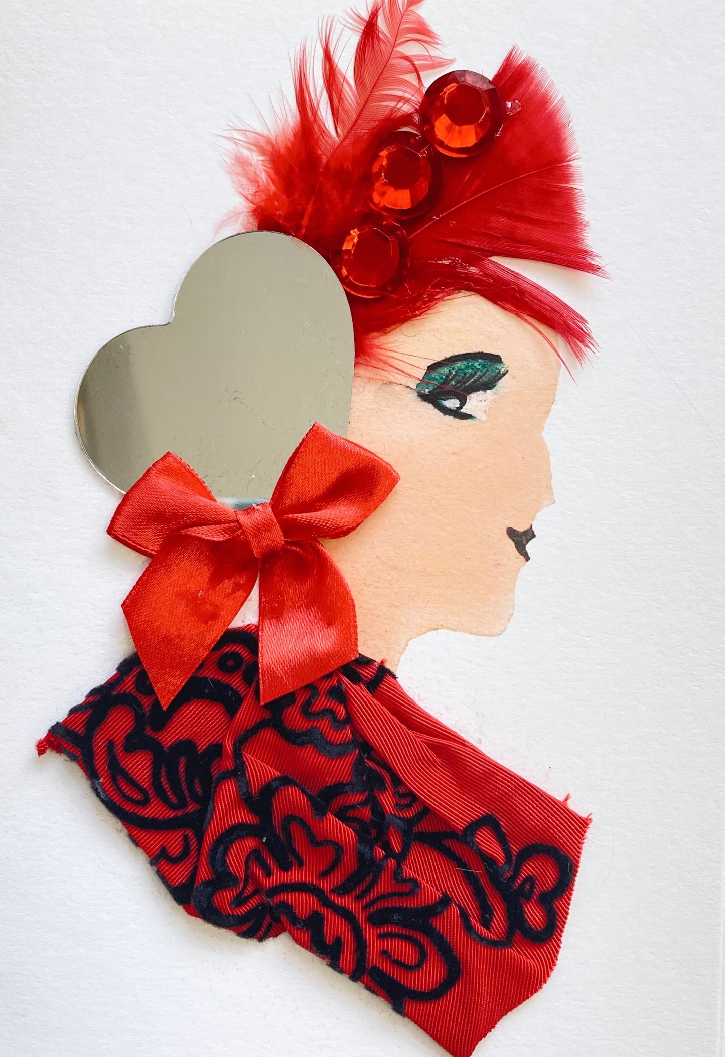 I designed this card of a woman named Camden Apple Chef. She has a white skin tone and has red feather hair and a mirrored heart barrette. She wears a red dress with a black floral print on it and a bow at the neckline.
