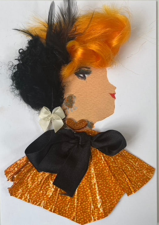 This card is called Wilma Watford. She is made from a metallic orange fabric as the blouse with a black bow on top, and there is a black feather and a white bow in her bright orange hair. 