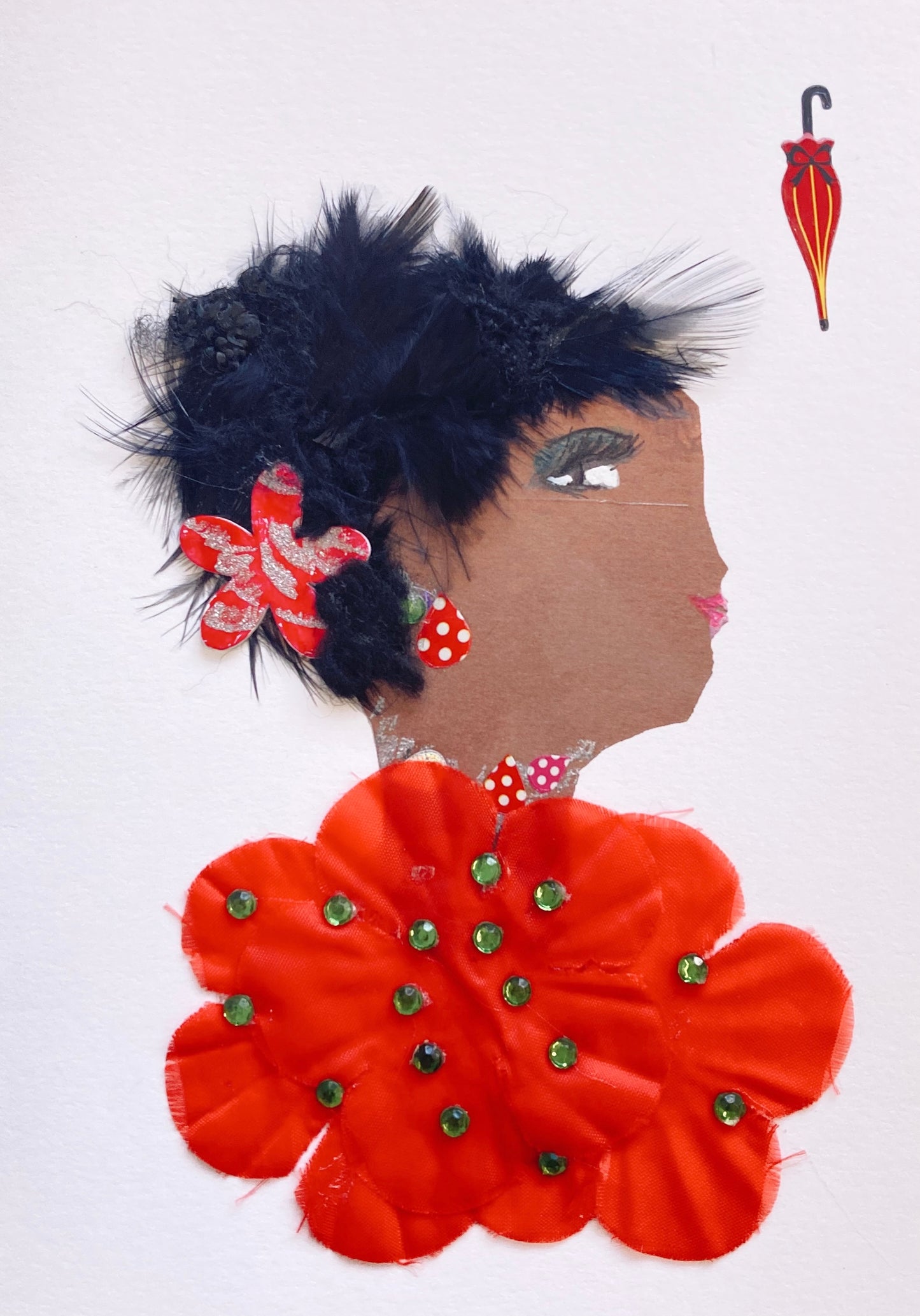 This card has been given the name red lily. She wears a red blouse made of flowers with green gems scattered, and a small red flower in her feathery black hair. In the top right corner, there is a small sticker of a red umbrella. 