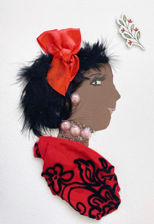 This card is of a woman given the name Narrow Harrow. She wears a red blouse made of a fabric which has black flower embroidery on it. Her jewellery is pink pearls. She wears a red ribbon bow in her short black hair. In the top right corner, there is a sticker of a branch with flowers coming out of it.