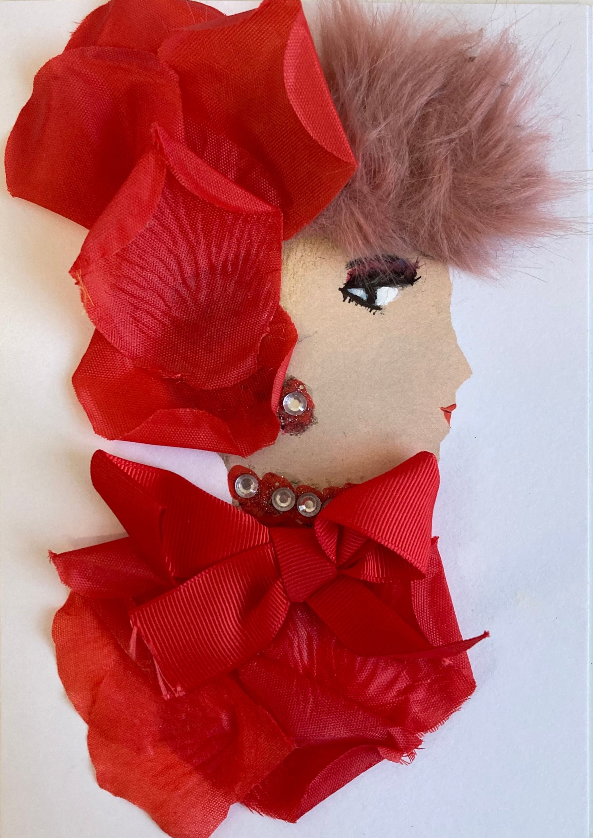 This card has been given the name Penelope Piccadilly. She wears red rose petals in her pink furry hair and as her blouse, which also has a large red bow on it. 