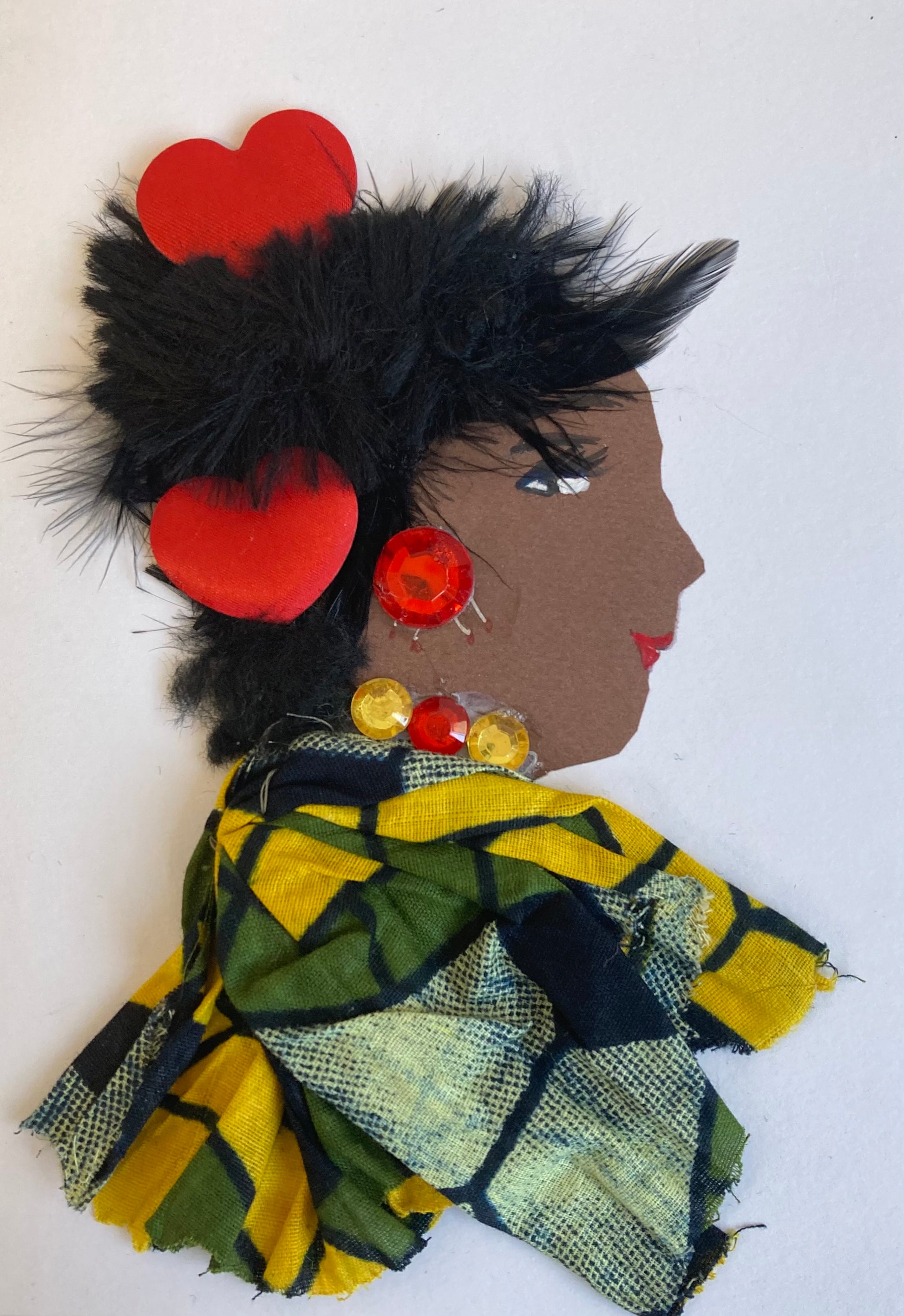 I designed this card of a woman named Glenda. She has a brown skin tone and is wearing a stunning patterned bloused filled with colours of green, yellow, and blue. There are two red hearts in her hair. She has on her statement red earrings and her yellow and red necklace to tie the look together.