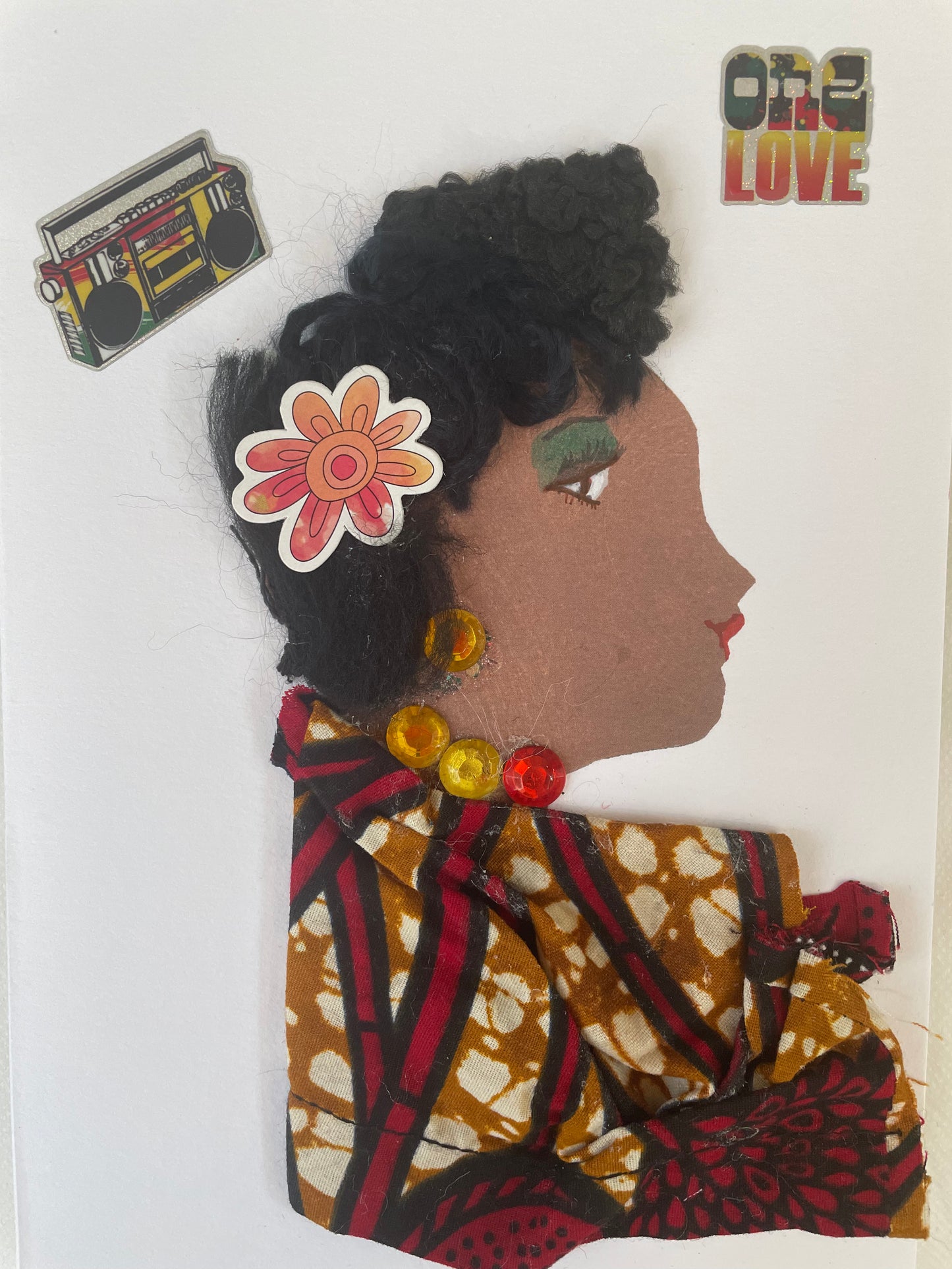 I designed this card of a woman named Brompton Benin. She wears a red and orange flower in her hair. She wears an ankara blouse. She wears yellow and red jewellery. In one corner it says one love and in the other corner there is a music player. 