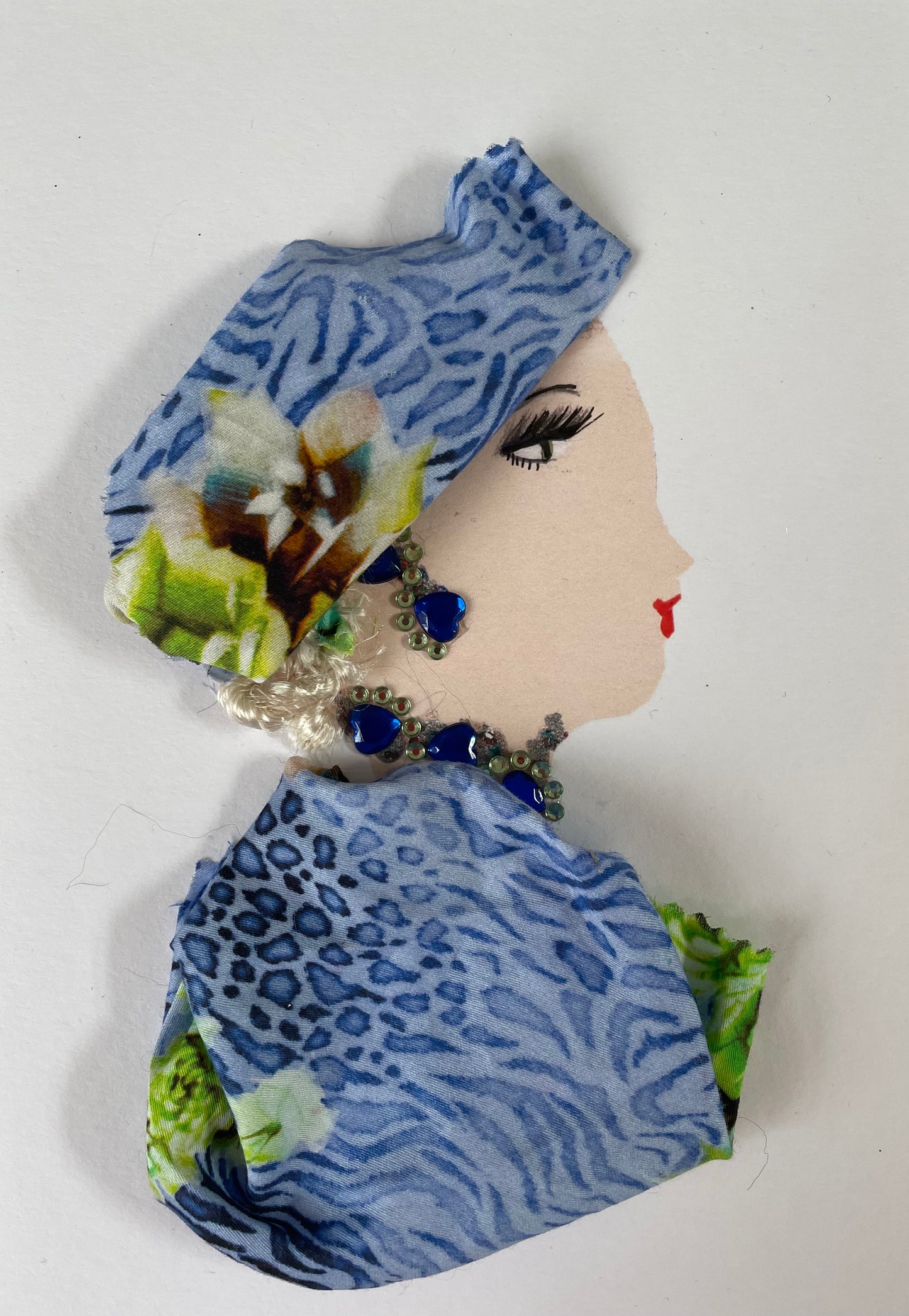 I designed this card of a woman named Dawn Dalston. She has a white skin tone and wears a blue floral headwrap. She wears a matching blouse. She wears silver and blue jewellery.