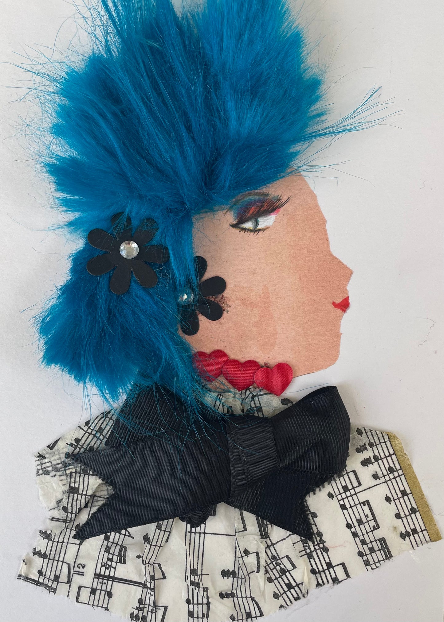I designed this card of a woman named Kensington Katherine. She has a white skin tone and vibrant blue hair. In her hair there are two black flowers. She wears a music print blouse with a black bow in the middle. She wears a red heart necklace. 
